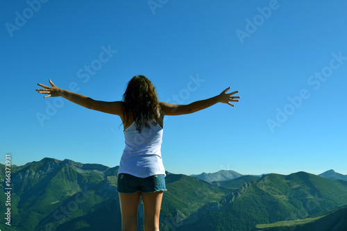 Silhouette man with hands rise up on beautiful view, upon the top of mountain. Concept freedom of life. 