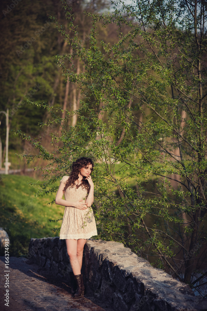 Brunette girl stands on the bridge near the water Brunette girl stands on the bridge near the water