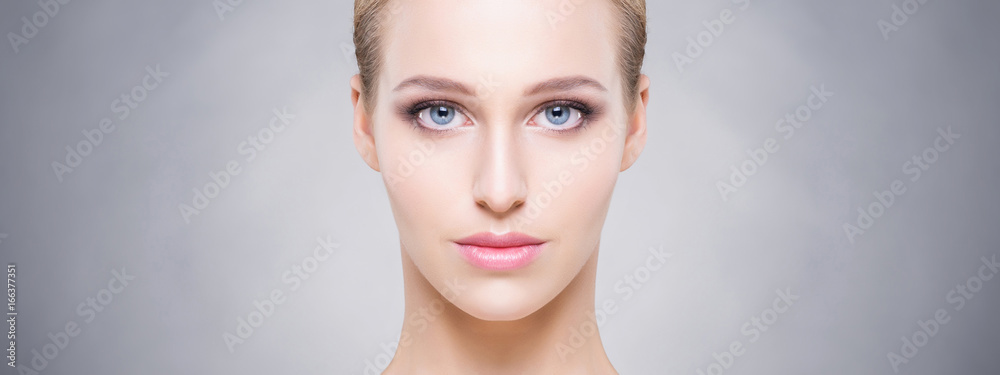 Fototapeta premium Beauty close-up portrait of beautiful, fresh and healthy girl over grey background. Make-up and skincare concept.