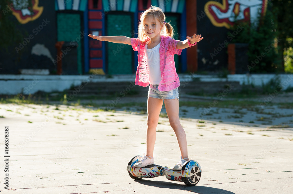 little girl riding on the hoverboard in the park foto de Stock | Adobe Stock