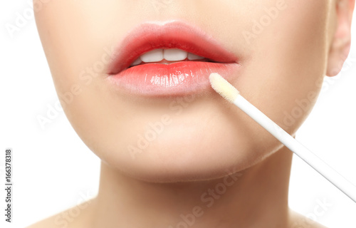 Young woman applying lip gl...