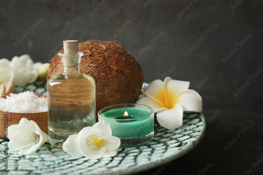 Beautiful spa composition with oil in bottle and coconut on platter