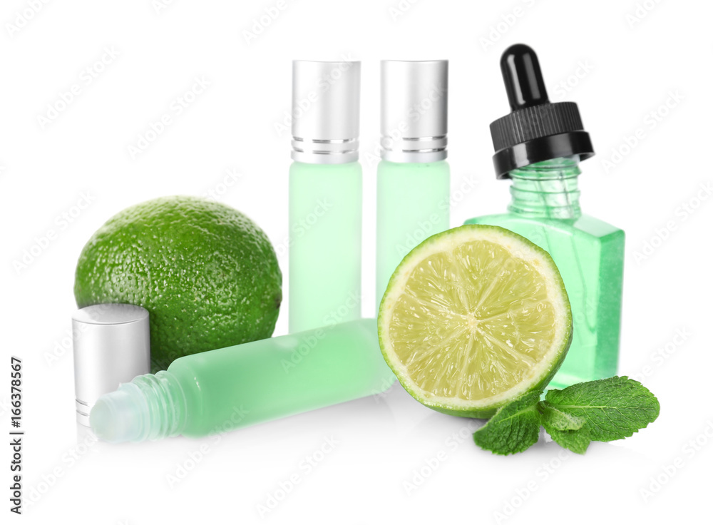 Bottles with perfume, leaves of mint and lime on white background Bottles with perfume, leaves of mint and lime on white background