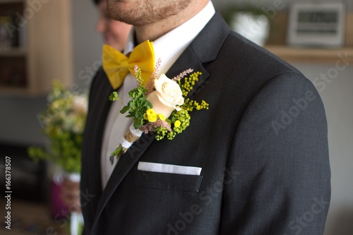 groom in suit with yellow bowtie
