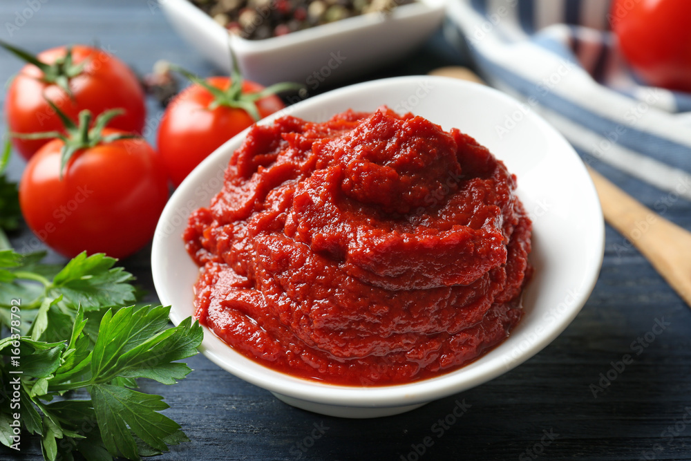 Ceramic bowl with tomato sauce and ingredients on wooden table Ceramic bowl with tomato sauce and ingredients on wooden table