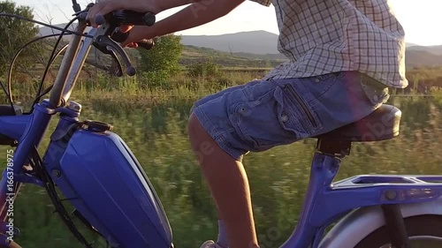 Boy drive moped at sunset