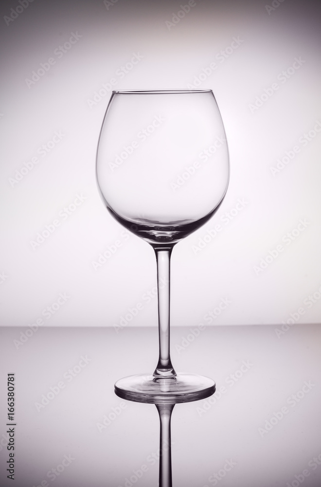 One empty wine glass on gray background