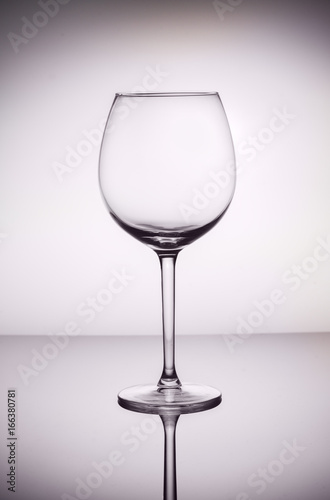 One empty wine glass on gray background