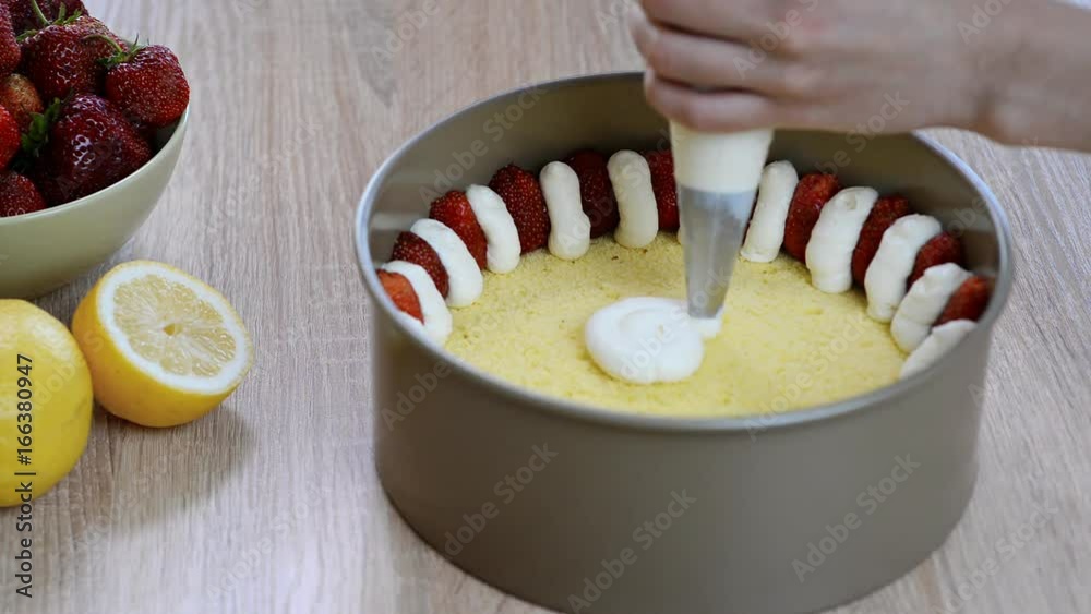 Chef squeezes cream. Hands squeezing whipped cream pastry bag. Making strawberry cake Chef squeezes cream. Hands squeezing whipped cream pastry bag. Making strawberry cake