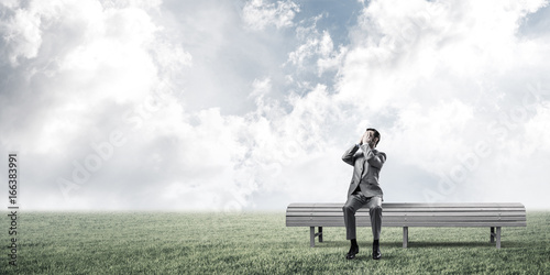 Young man in summer park on bench do not want to see anything