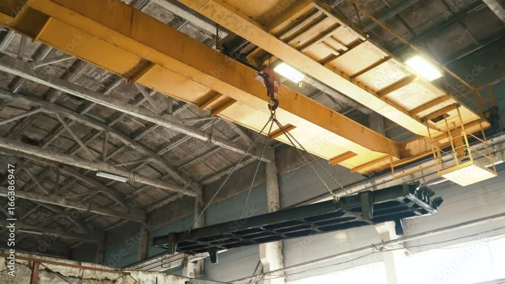 Overhead crane moves concrete slab in large at the old plant. Manufacture of reinforced concrete structures. 