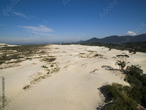 Fototapeta Naklejka Na Ścianę i Meble -  Aerial view Dunes in sunny day - Joaquina beach - Florianopolis - Santa Catarina - Brazil. July, 2017