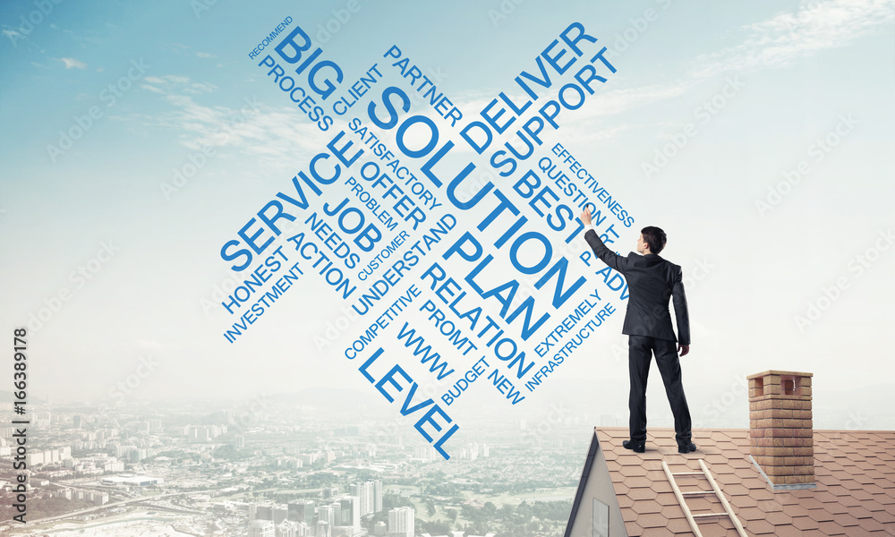 Young businessman standing on house roof and writing leadership Young businessman standing on house roof and writing leadership