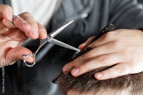 men s haircut with scissors at salon