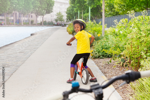 African girl riding bicycle on cycle lane in city