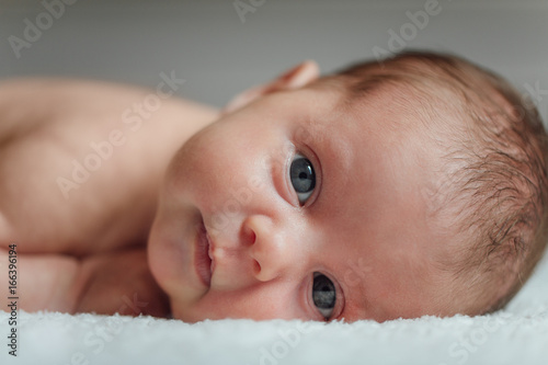 Close-up of newborn baby girl lying on bed photo
