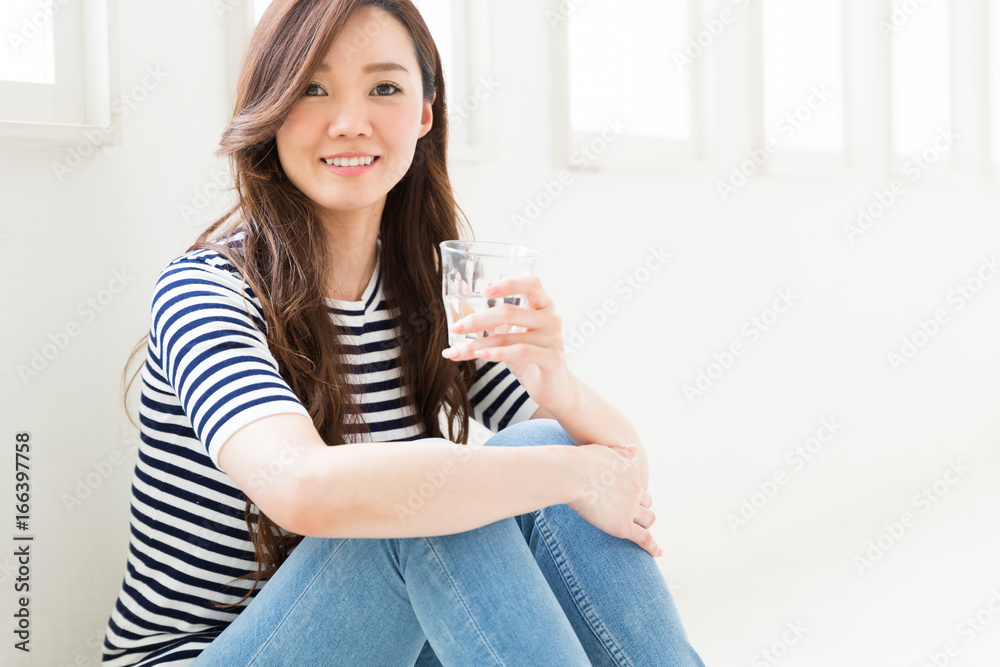 部屋で水を飲む女性 部屋で水を飲む女性