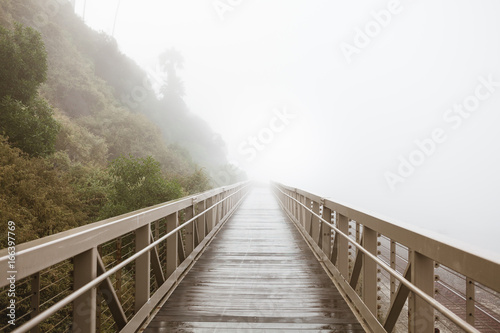 Foot bridge along the coast on a foggy morning,