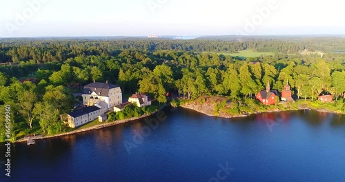 Fagervik, Cinema 4k aerial sideway view of a yellow mansion and fagervik steelworks, at a sunny evening, in Inkoo, Uusimaa, Finland photo