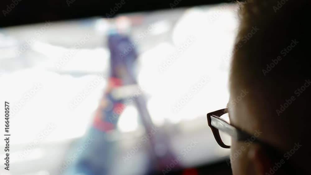 Young man with eyeglasses play video game using a big screen. Young man with eyeglasses play video game using a big screen.