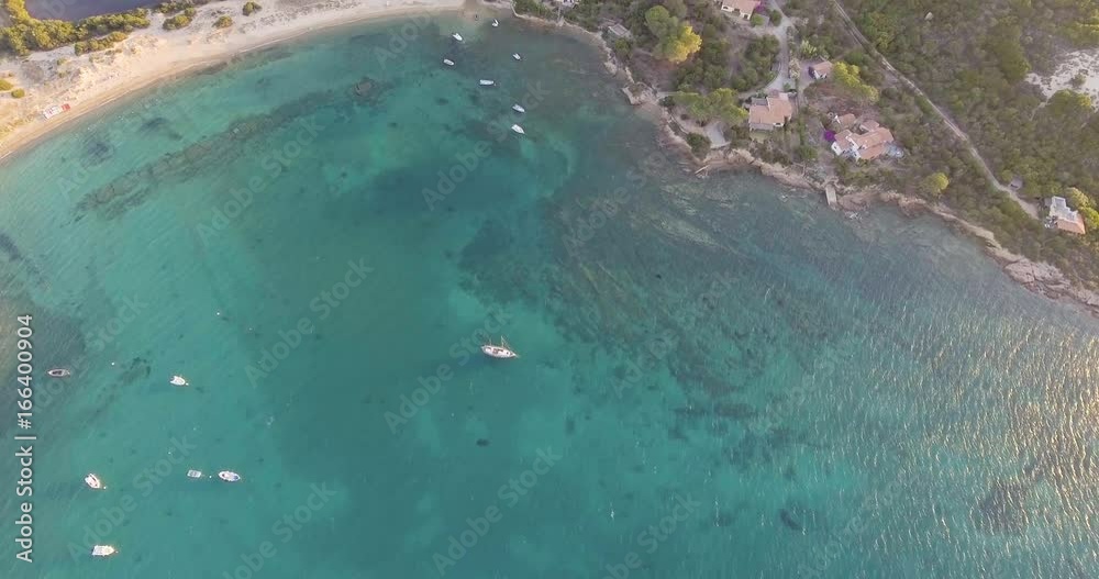Aerial, beautiful bay in Sardinia island and few ancored yachts on sunset, 4K