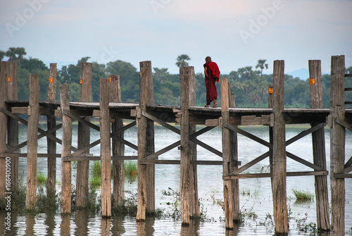 Monk walking on U Bein Bridge near Amarapura, Myanmar. photo