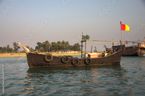 Slika na platnu Small fishing boat sailing under Bangladeshi flag