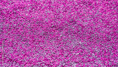Background of colorful purple sprinkles. Food texture and pattern.
