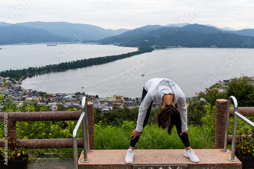 Woman viewing the landscape upside down in Amanohashidate in Kyoto