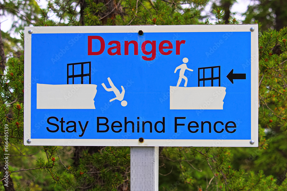 Closeup of a danger stay behind fence sign
