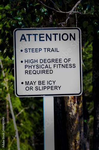 An attention steep trail sign with additional warnings