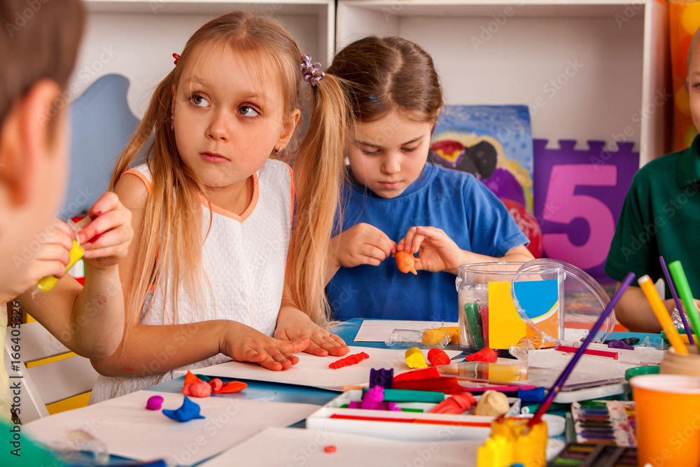 Child dough play in school. Plasticine for children. mold from plasticine in kindergarten .Kids knead modeling clay with hands in preschool. Preparing for a school exhibition of plasticine.