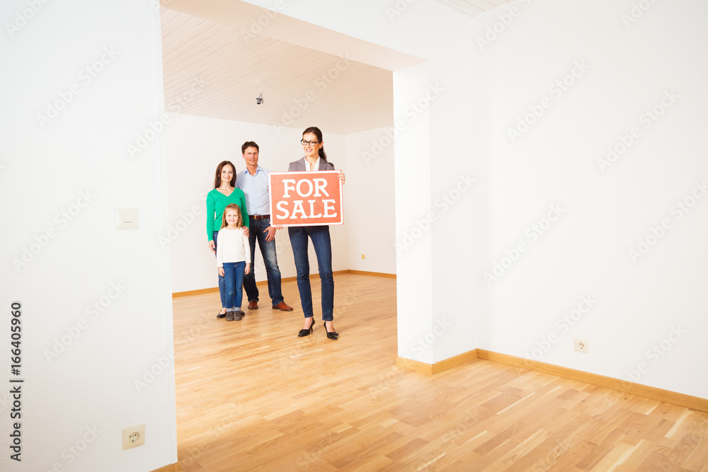 Realtor In Empty Apartment, Holding 'for Sale' Sign