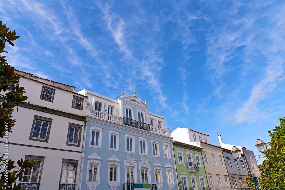 Sunny day in Ponta Delgada, Azores capital city, Portugal. Facades of buildings under the blue sky with clouds in summer.