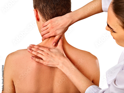 Shoulder and neck massage for man in spa salon. Doctor making neck therapy in rehabilitation center. Folded towels in the background. Correction of dislocation of the neck.