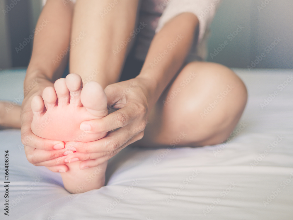 health care concept. woman massaging her painful foot, red hi-lighted on pain area health care concept. woman massaging her painful foot, red hi-lighted on pain area