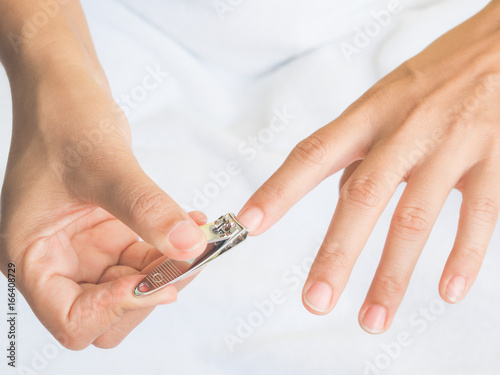 Closeup of a woman cutting nails, health care concept.