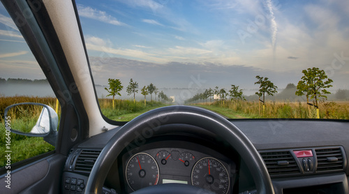 A view of the cockpit of a car driving .The way in the morning.