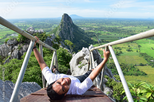 asian man is climbing on the bridge to Khao Nor mountain, Nakhon Sawan, Thailand