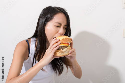 Woman eating burger over white background