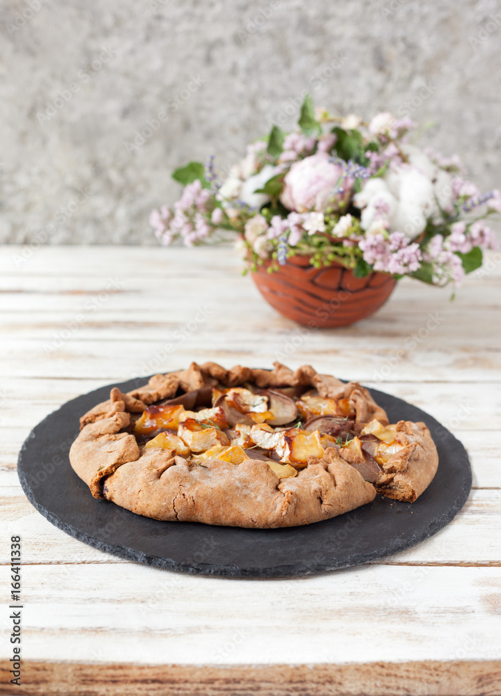 Galette with pears and cheese Brie. Called also Breton galette, galette des Rois, Galeta. French cuisine (food). On old wooden white background. Galette with pears and cheese Brie. Called also Breton galette, galette des Rois, Galeta. French cuisine (food). On old wooden white background.