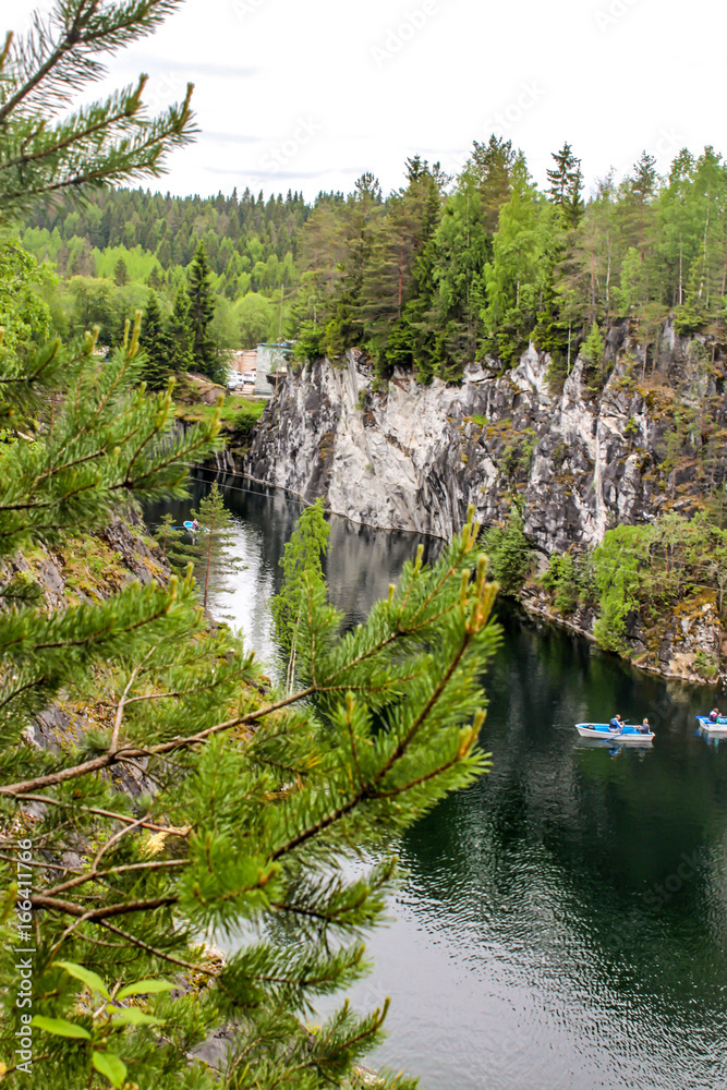People in a boat sail in the lake, Marble Canyon Ruskeala, Republic of Karelia, Russia
