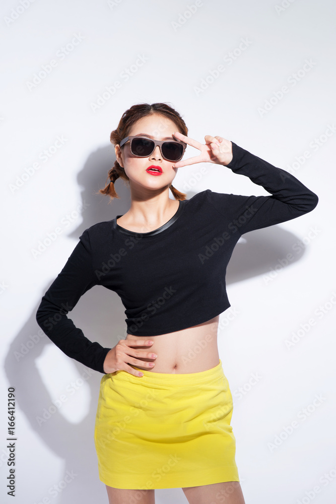 Young asian girl doing emotion. Dressed in a black shirt and yellow skirt. Warm color. White background, not isolated Young asian girl doing emotion. Dressed in a black shirt and yellow skirt. Warm color. White background, not isolated