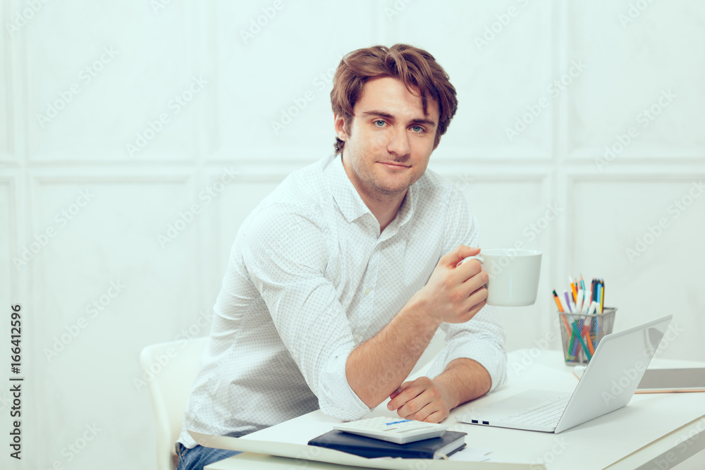 Businessman using laptop with tablet and pen