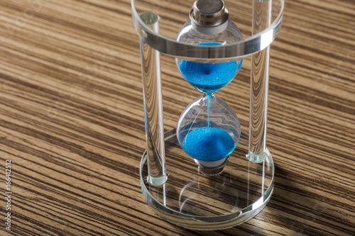 Time is passing. Blue hourglass close up