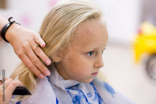 Little girl make hairstyle.
