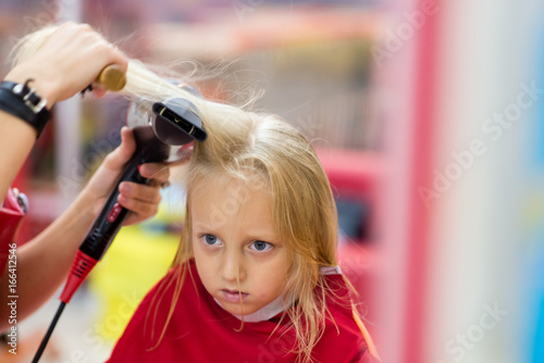 Little girl doing a haircut.