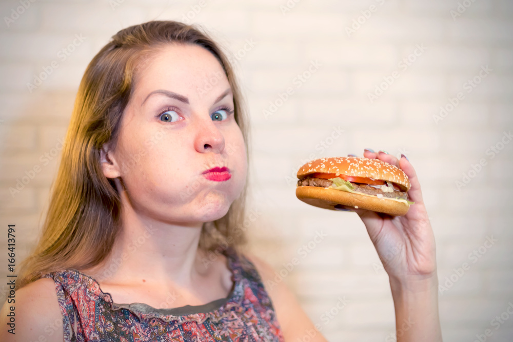 Young woman eating hamburger and cheeks Young woman eating hamburger and cheeks