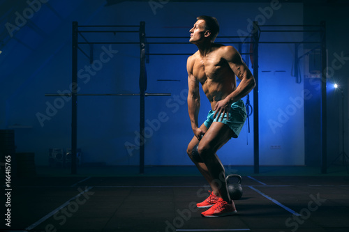 Sporty muscular adult exercising with kettle bell © pavel_shishkin