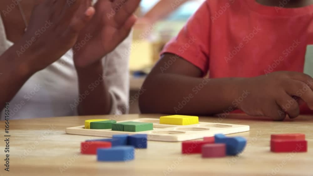Teacher And Pupils Using Wooden Shapes In Montessori School Teacher And Pupils Using Wooden Shapes In Montessori School